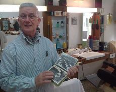 Paolo Cencioni, il barbiere di Montalcino sfoglia alcune foto che ricordano i suoi anni di attività 