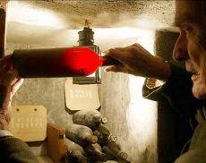 Franco Biondi Santi analizza alla luce di una lanterna una inestimabile bottiglia di Brunello Riserva 1891